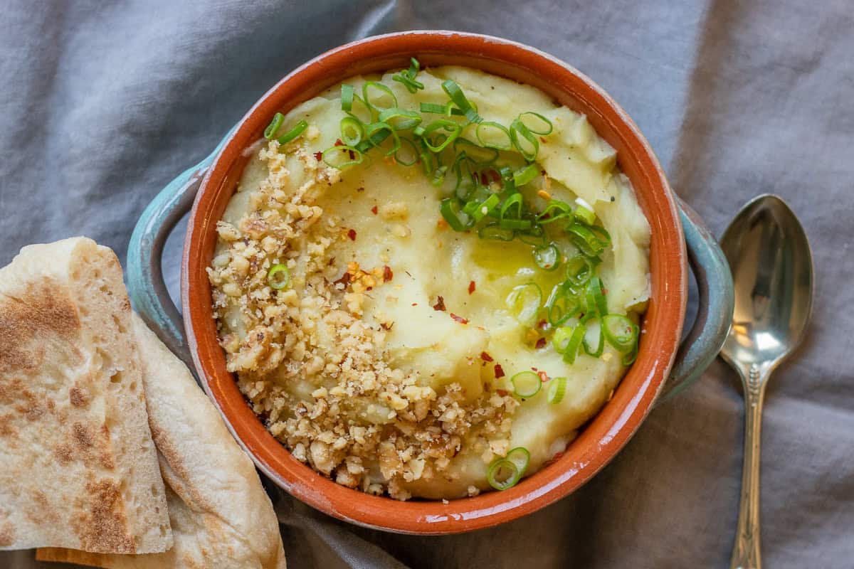 skordalia dip is garnished and served with flatbread