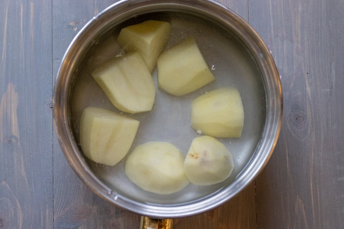 peeled potatoes are placed in a pot with cold water