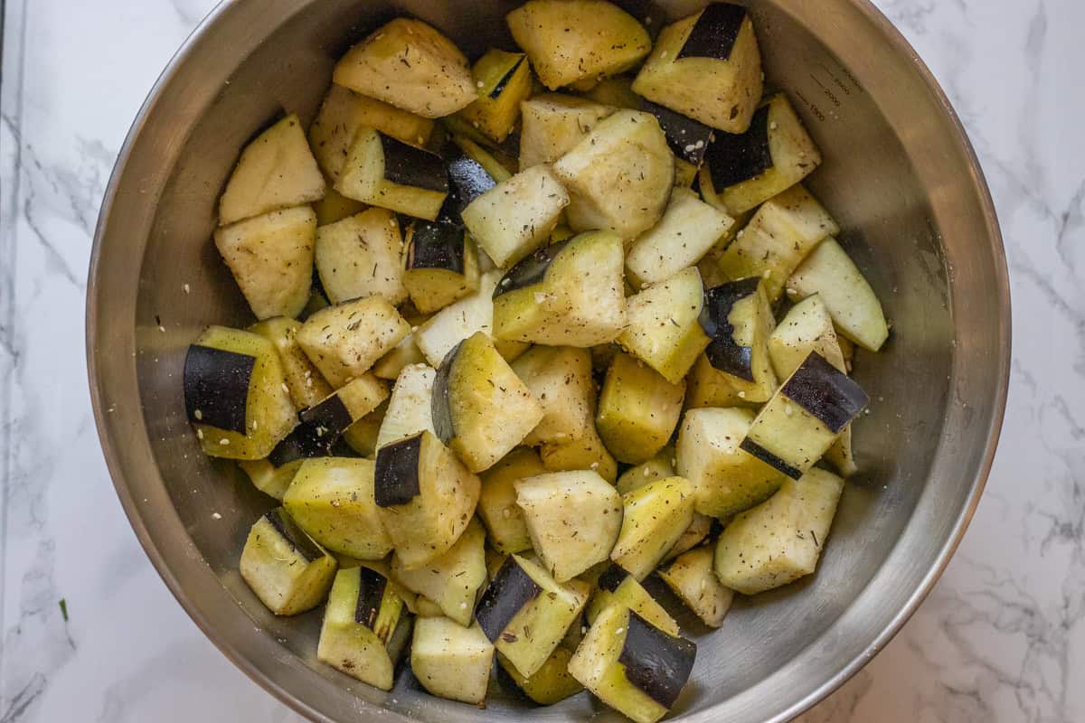 diced eggplant pieces are mixed with olive oil