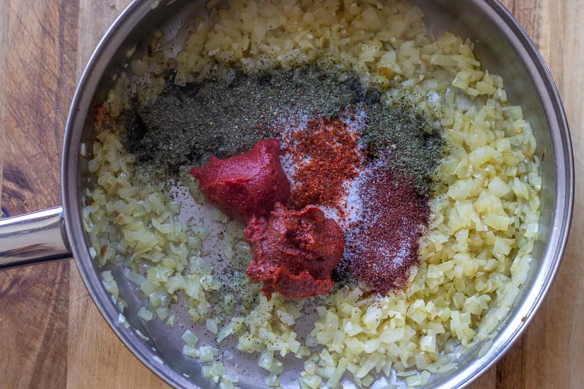 spices and tomato and pepper paste are added to sautéed onions