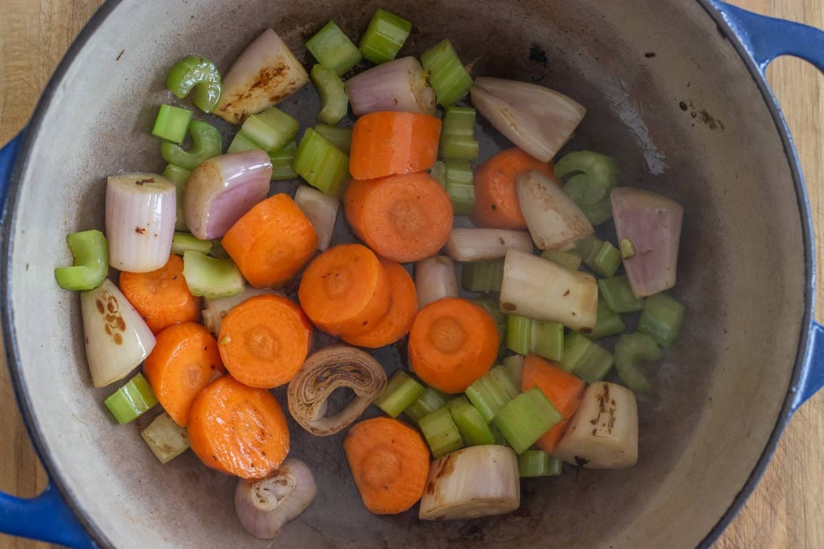 sautéing shallots, carrots, and celery in a pot