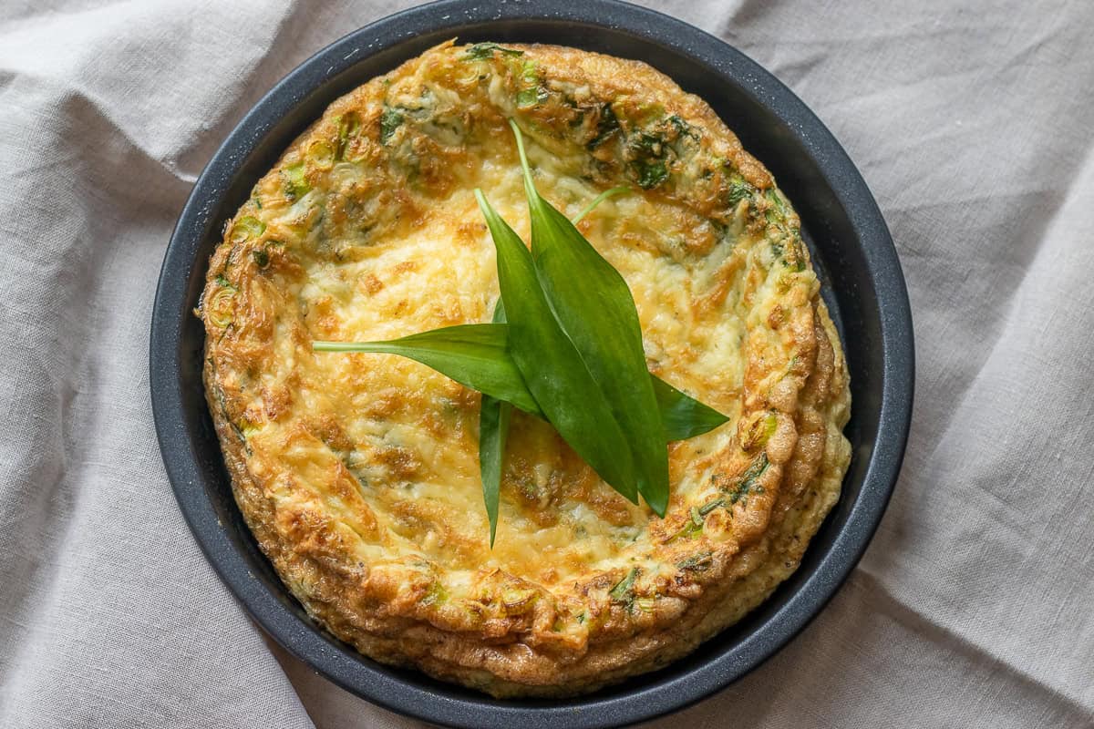 frittata with greens and cheese in a black dish