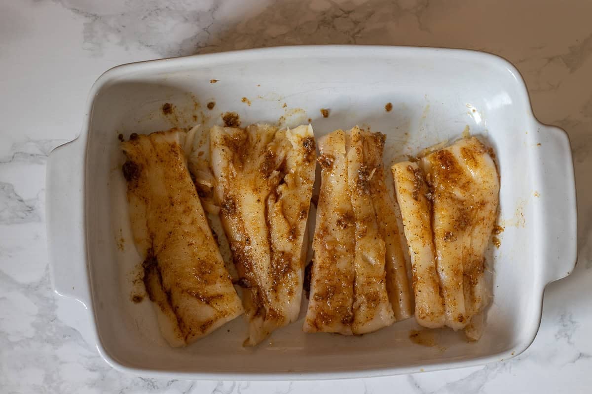 fish fillets are covered with olive oil and seasoning