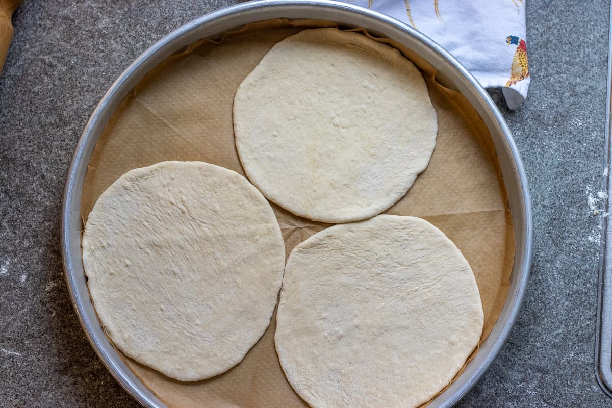 3 pieces laffa bread are placed on a baking tray