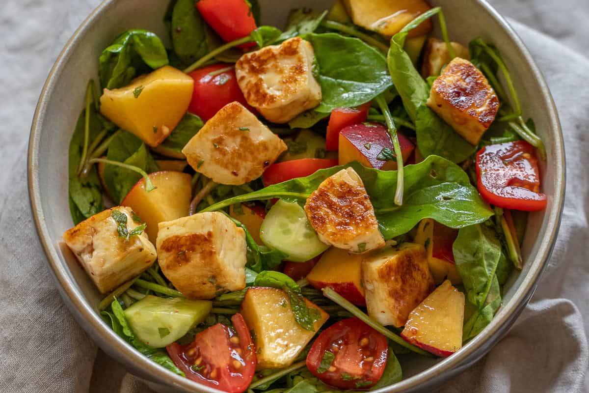 mediterranean style halloumi salad made with peaches and vegetables