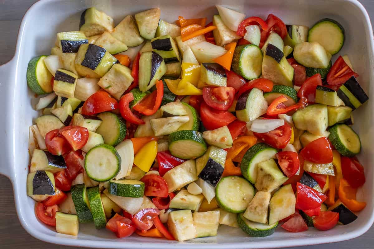 chopped vegetables are placed in a baking dish