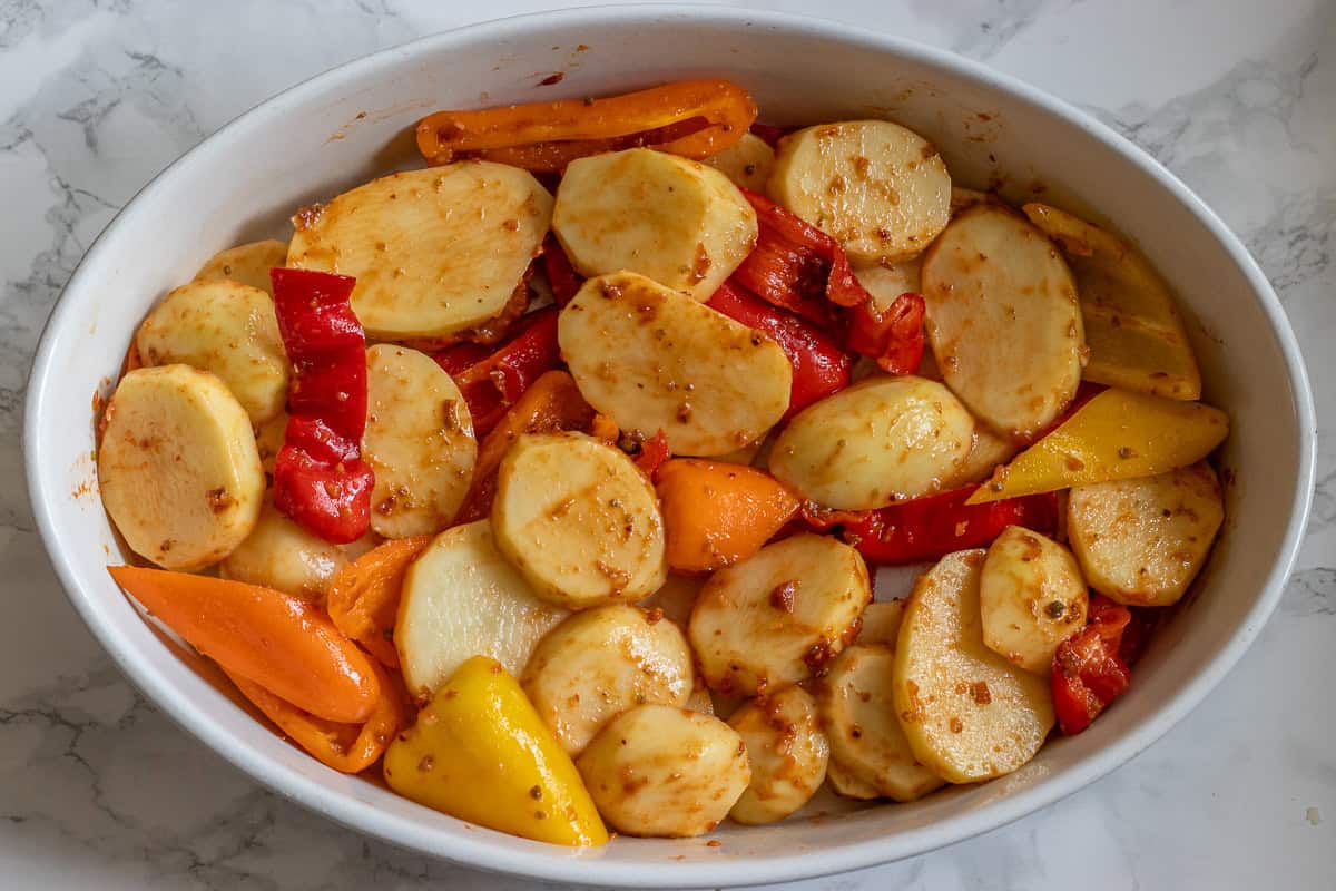 potatoes and peppers are layered on a baking dish