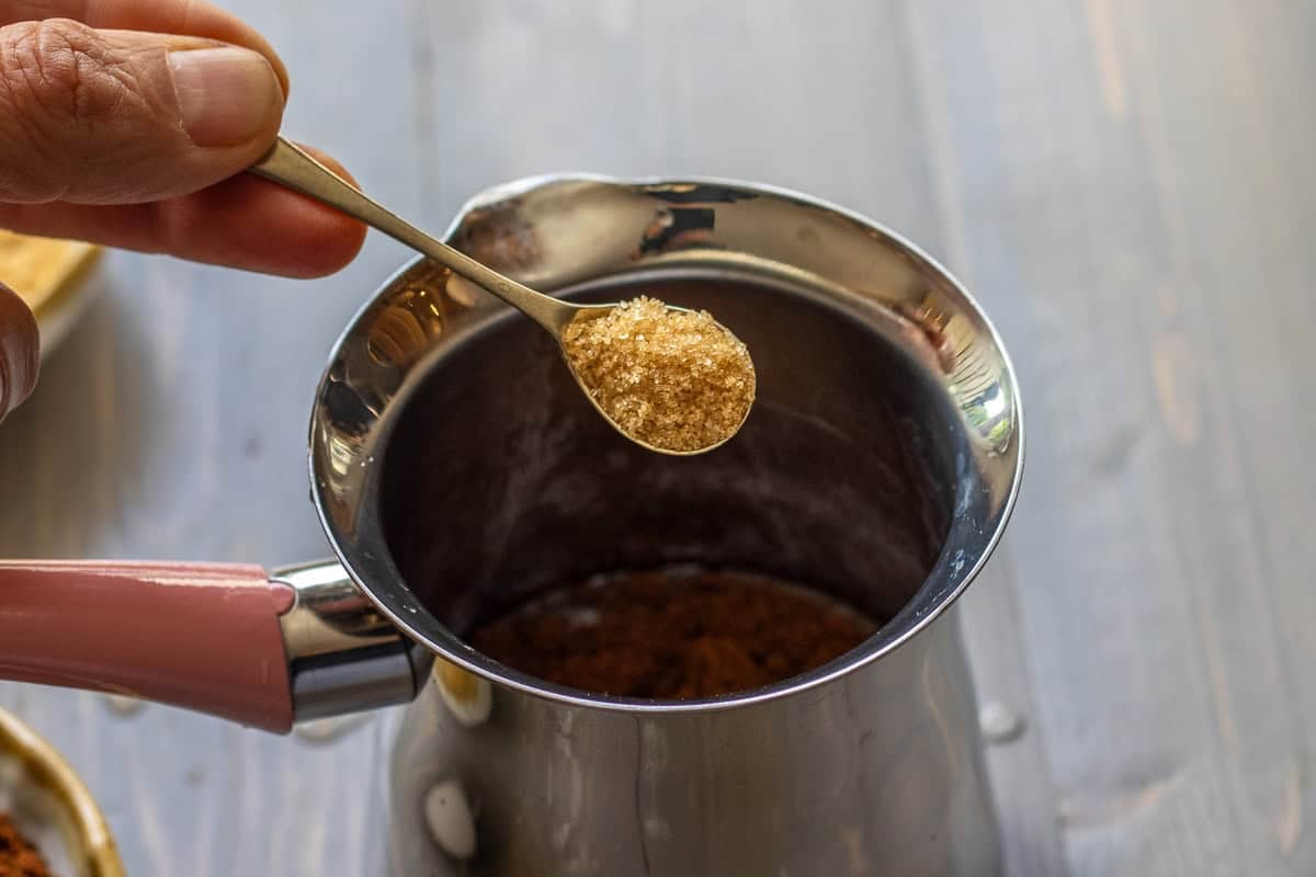 adding a small teaspoon of sugar to cezve for making turkish coffee