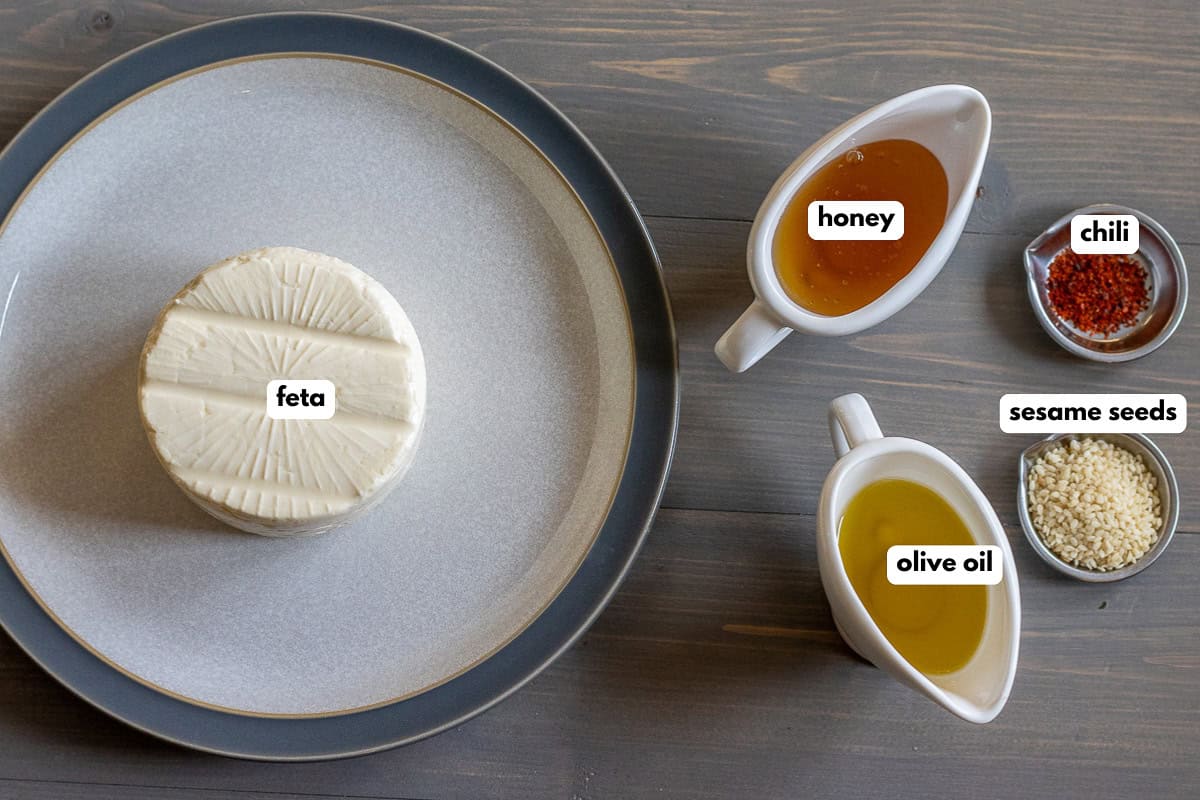 labelled picture of ingredients for baked feta with honey and sesame seeds