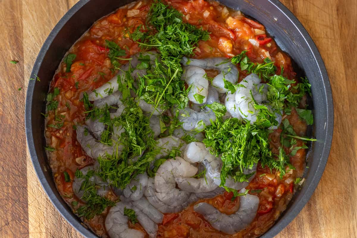 shrimp and fresh herbs are added to shrimp saganaki