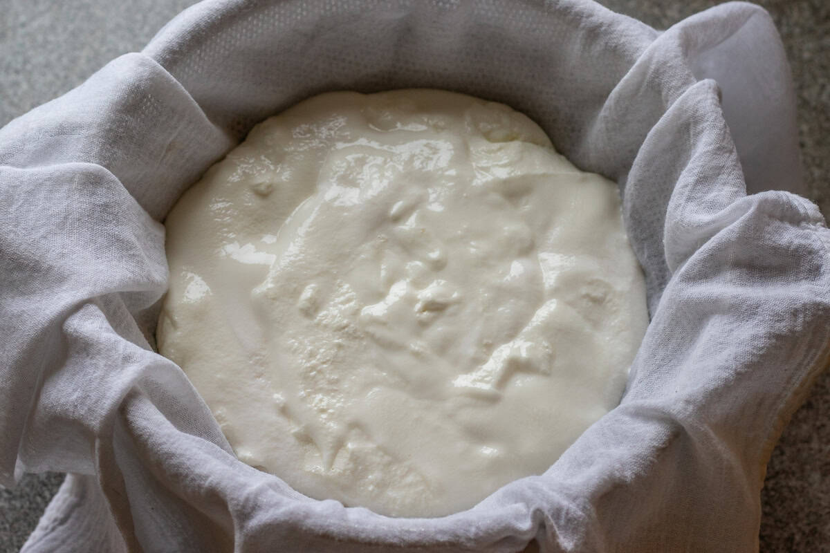 straining yogurt over cheesecloth