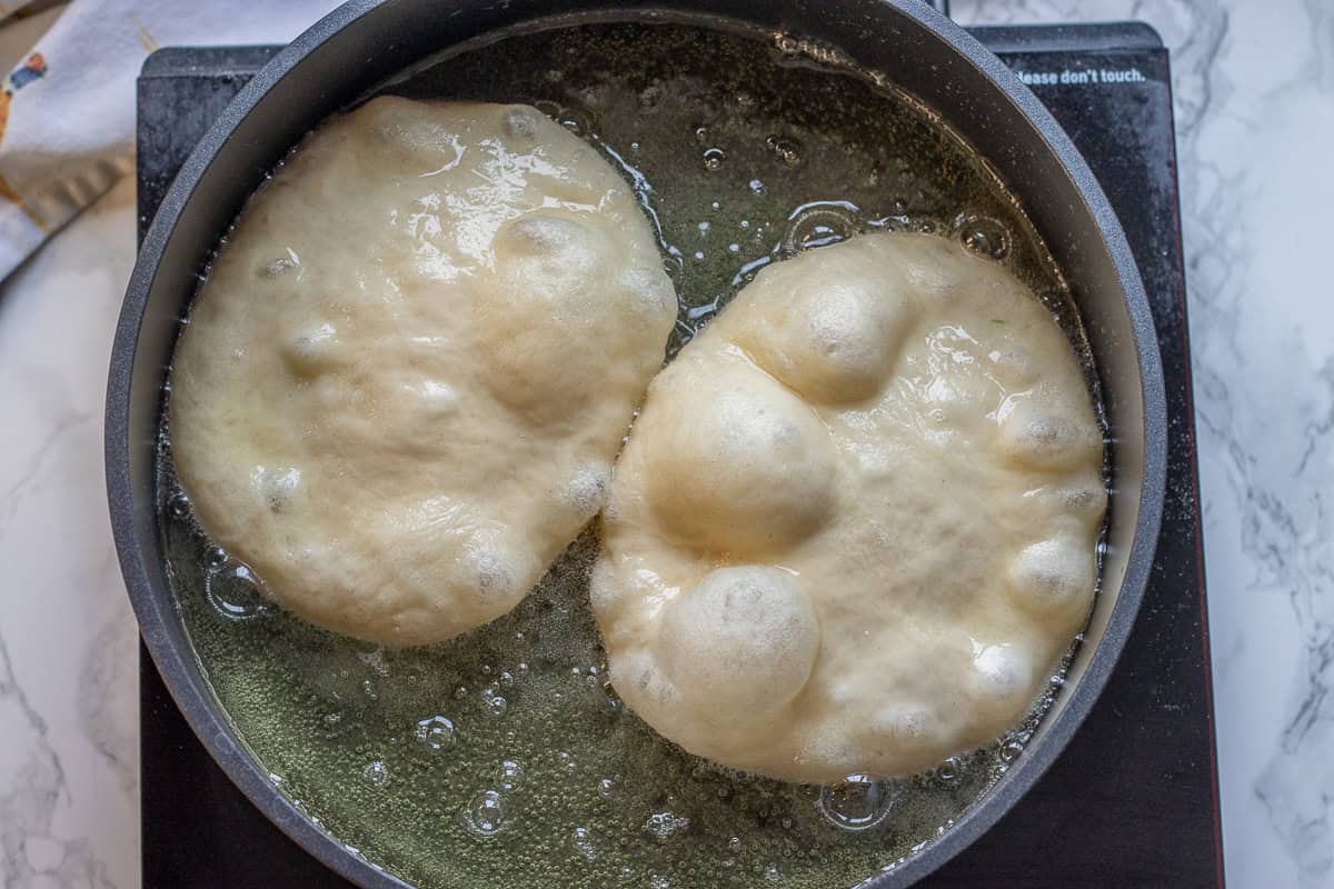 frying two pieces of pisi dough in hot oil