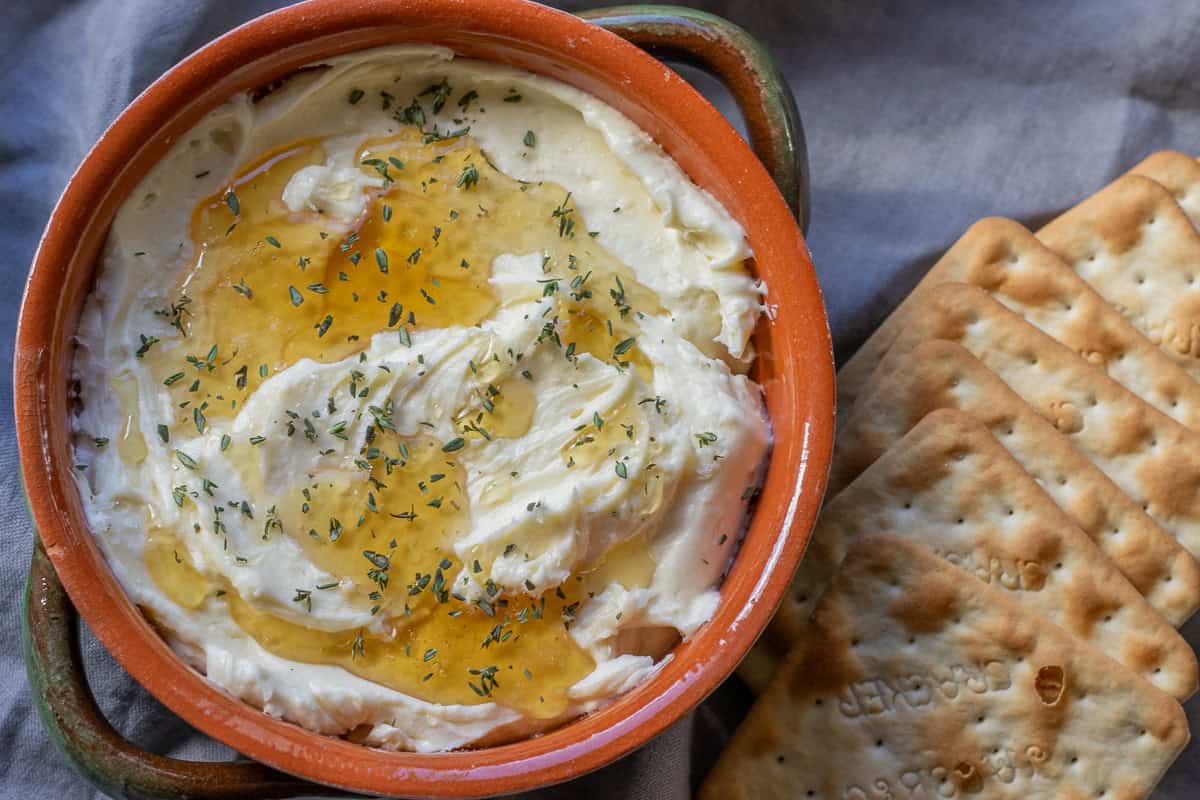 Whipped brie with honey served in a bowl with cheese crackers