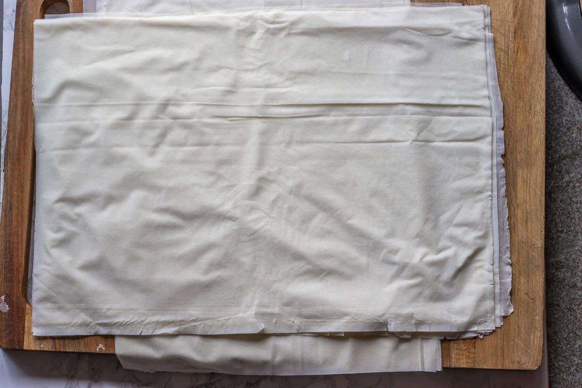 phyllo sheets are cut into two to fit in a tray